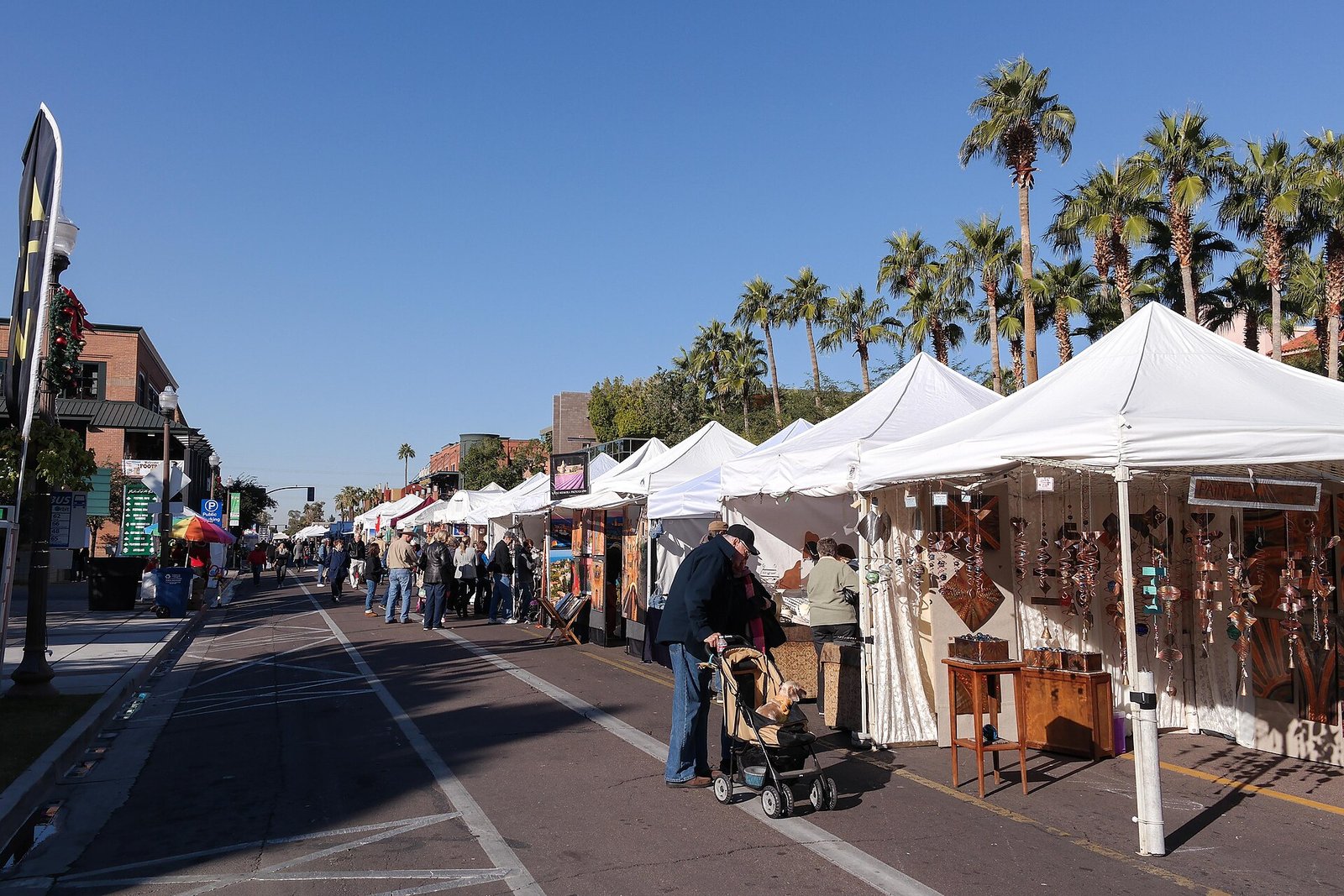 A lively palm-lined street filled with artists and visitors at the Tempe Festival of the Arts